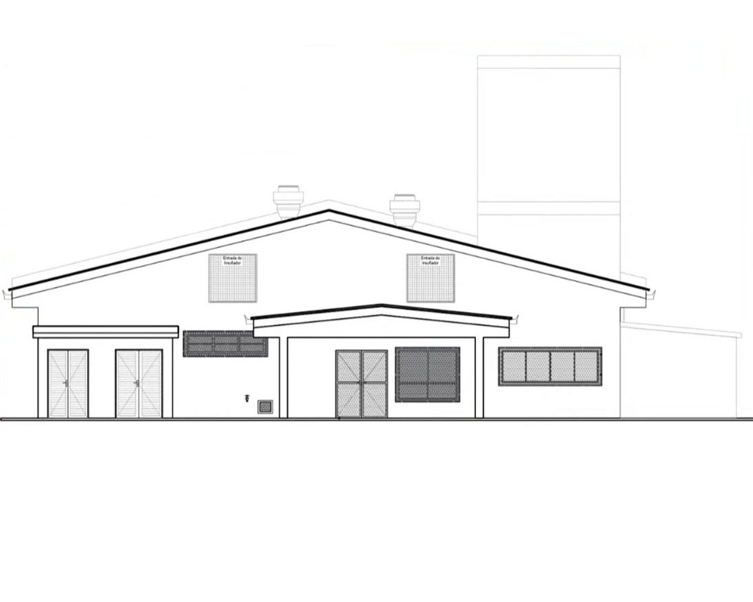 Desenho técnico em preto e branco da fachada de uma edificação. A construção possui telhado de duas águas, com um volume central avançado que marca a entrada principal. Na parte frontal há portas, janelas e aberturas de ventilação representadas por linhas e hachuras. Sobre o telhado aparecem dois exaustores e, à direita, uma estrutura vertical alta semelhante a uma chaminé. A imagem apresenta apenas os contornos arquitetônicos, sem cores ou elementos de paisagismo.